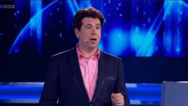 Screenshot of a man in a suit speaking.
