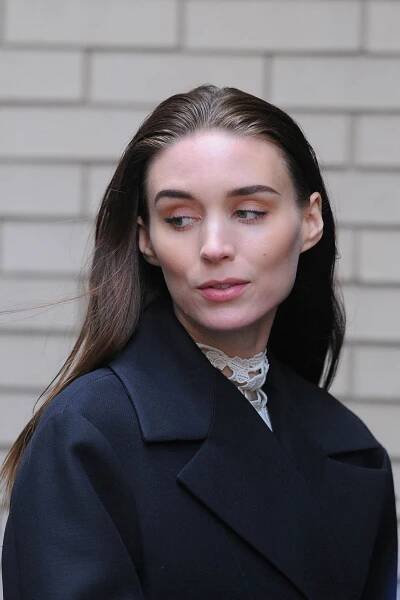 a woman with long hair wearing a black coat