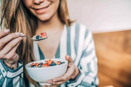 Crop,Woman,Close,Up,Eating,Oat,And,Fruits,Bowl,For