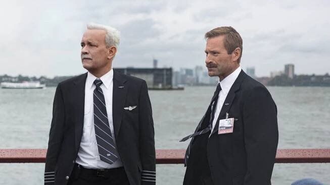 Tom Hanks v roli kapitána Sullyho (na snímku vlevo, vpravo je herec Aaron Eckhart) přistane s poškozeným letadlem v ledových vodách řeky Hudson.