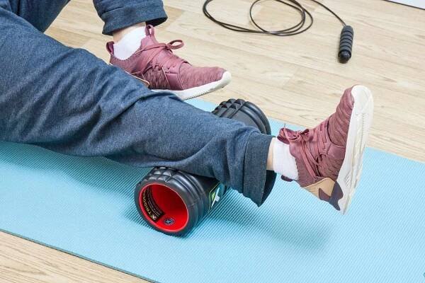 A person using the TriggerPoint Grid X Foam Roller on their calf
