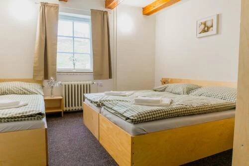 a bedroom with two beds and a window at Chata Prim in Deštné v Orlických horách
