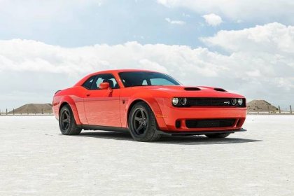 A red 2023 Dodge Challenger parked on a beach.