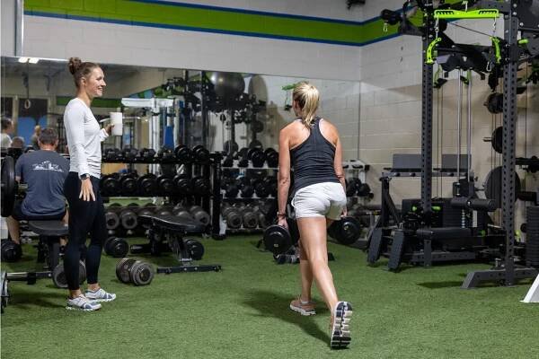 Prevail trainer working with a client doing dumbell lunges