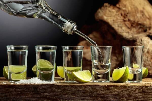 stříbrná tequila se solí a plátky vápna na staré dřevěné desce. - alcohol - stock snímky, obrázky a fotky