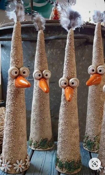 four ceramic turkeys sitting on top of a wooden table next to each other with googly eyes
