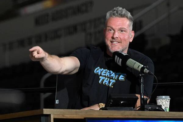 Pat McAfee speaking into a microphone at an NBA event.