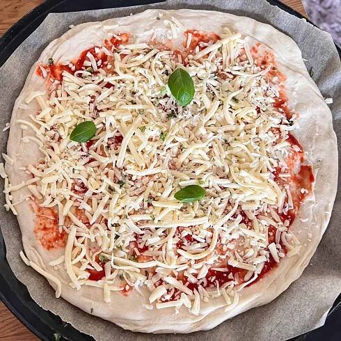 Uncooked cheese and tomato margherita pizza.