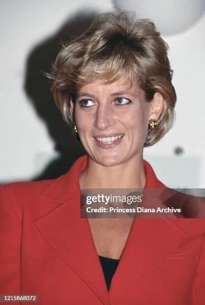 British royal Diana, Princess of Wales , wearing a red two-piece suit by Catherine Walker, during a visit to London Lighthouse, a centre for people...