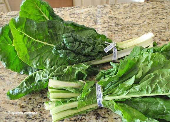 Two bunches of fresh Swiss chard on the counter.