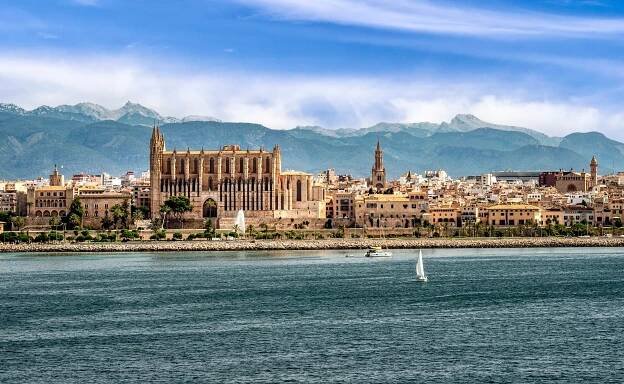 Palma de Mallorca cityscape with cathedral and mountains in the background.