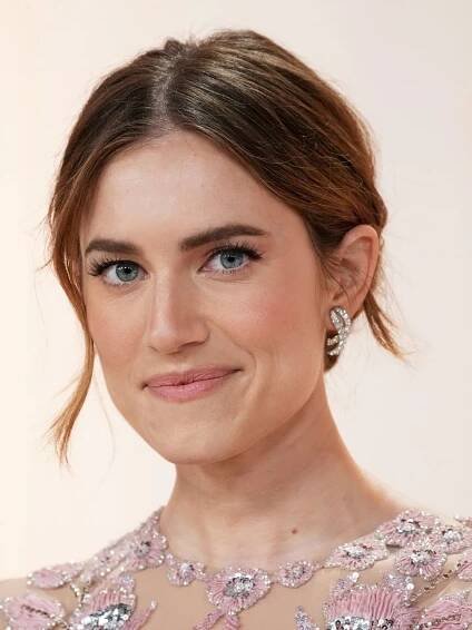 a woman with blue eyes wearing a pink dress