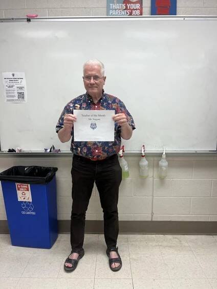 Mr. Nugent proudly holds his Teacher of the Month Award.