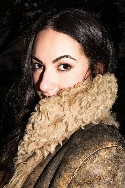 Zoe Kestan, peering over the fur collar of a leather jacket.