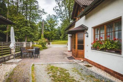 a house with a patio and a table and chairs at Penzion u lázní in Velké Losiny