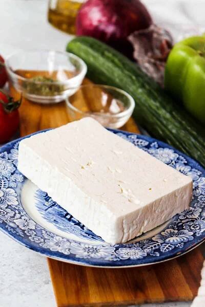 A good slice of feta cheese on a blue plate