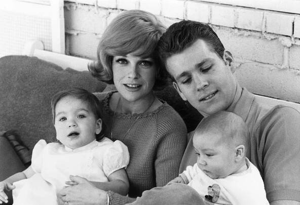 Ryan O'Neal seated with his eight month-old baby son, Griffin, and his wife, actor Joanna Moore, who has their daughter, Tatum