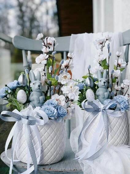 two white baskets filled with blue and white flowers