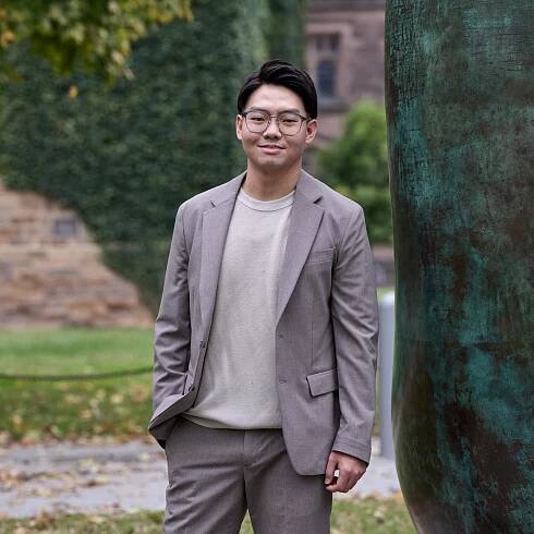 Kevin Kwak, standing near a campus sculpture