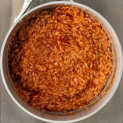 cooking Mexican red rice in a pot.