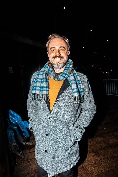 A Peter Kay fan outside his London O2 gig in a scarf and grey coat