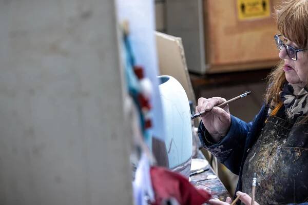 Anita-Harris-Concentrating-on-decorating-a-biscuit-fired-pot-©-Paul-Worpole-Photography