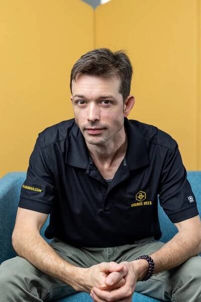 man leaning forward in black polo
