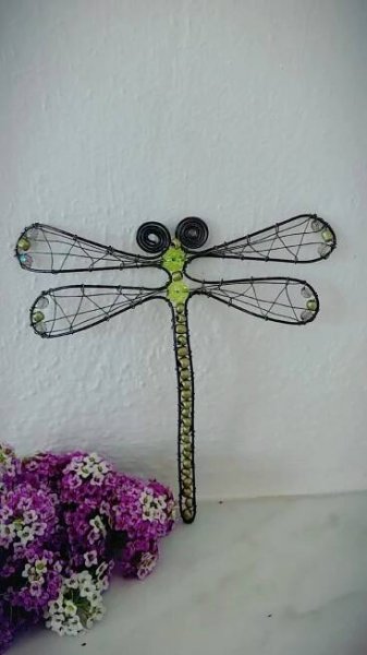Metall-Libelle auf weißer Mauer