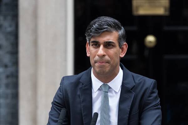 a man in a suit and tie is speaking into a microphone