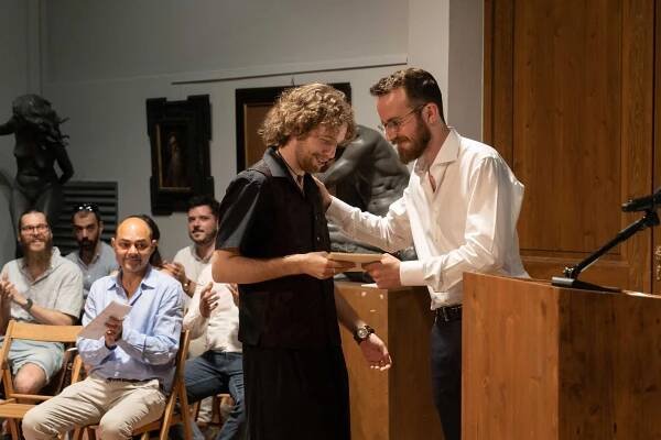 Intermediate Program Student Alexander Kai recieves an award for best figure painting from Program Director, Toby Neve