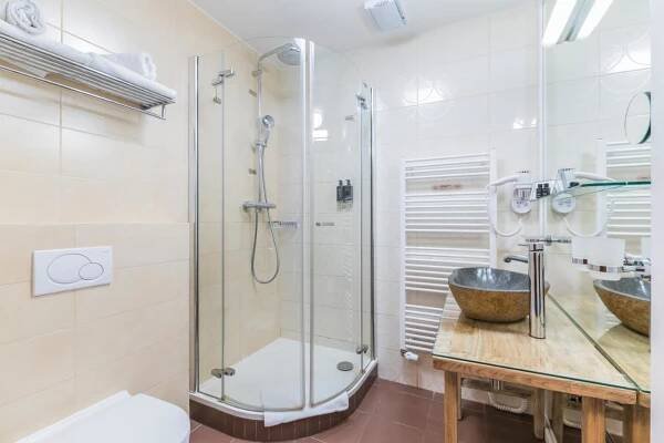 a bathroom with a shower and a sink at Wellness & spa hotel Augustiniánský dům in Luhačovice