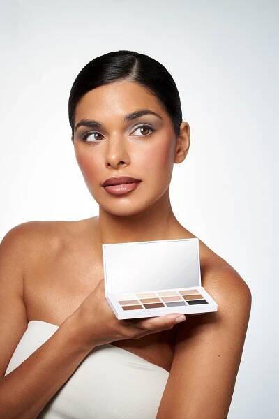 A woman holding a box of makeup by Mario.