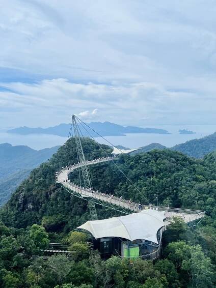 The famous curved Langkawi Sky Bridge snaking across lush green mountains in Malaysia.
