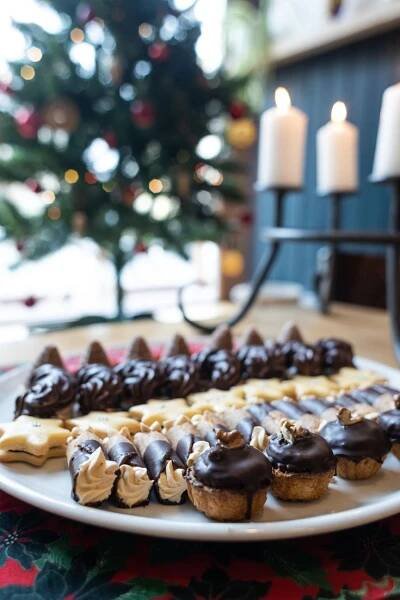 chocolate covered cookies on a plate with candles in the background