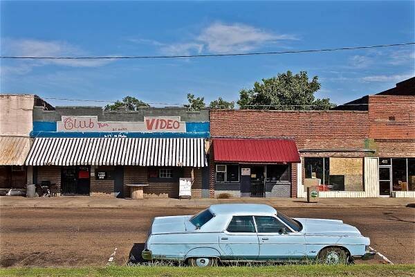 Landscape photo of an empty street with an old blue car in front of Club Video in day light. Photos of various people & locations on and around Highway 61, The Blues Highway that runs north from Memphis, Tennessee to New Orleans, Louisiana. Shot for a number of projects such as the documentary We Juke Up In Here, the web series Moonshine & Mojo Hands, a passion project to document the beautiful Mississippi delta lifestyle. As an on location photographer, lifestyle photographer & location commercial photographer, this was one the best long term projects ever that captures southern Americana!