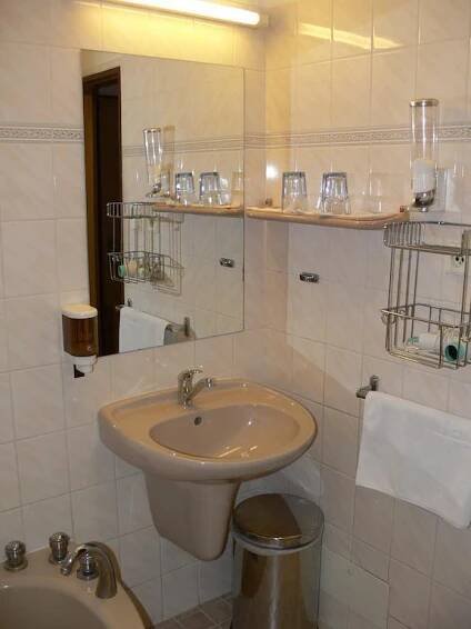 a bathroom with a sink and a toilet and a mirror at Penzion Oaza in Luhačovice