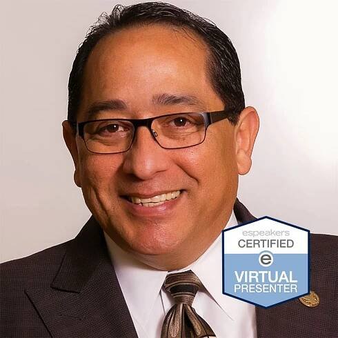 Smiling man in glasses and suit with virtual conference badge.