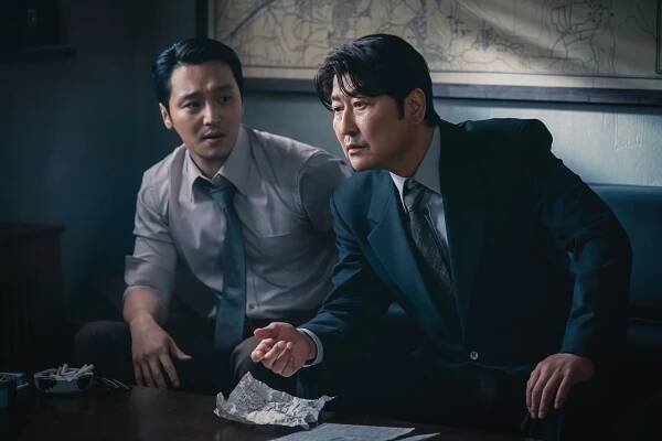 Byun Yo-han and Song Kang-h wearing suits and ties at a table in 'Uncle Samsik'
