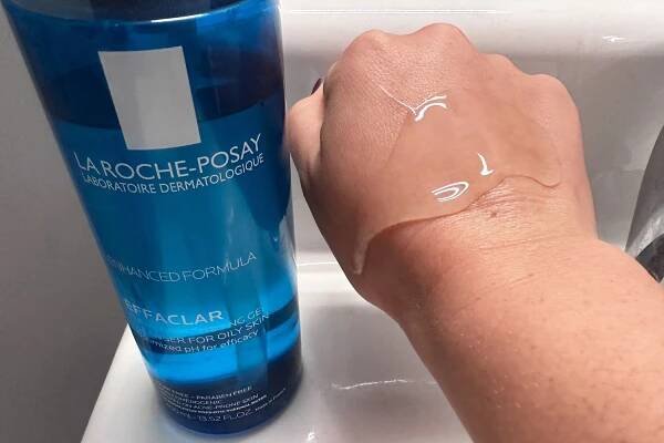 A large glob of La Roche-Posay Effaclar Purifying Foaming Gel Cleanser on the back of a hand hovering near the bottle