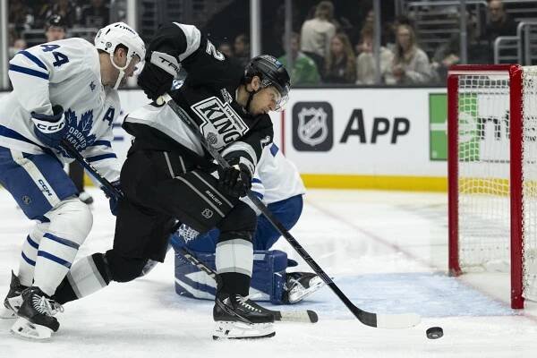 Kings forward Trevor Moore reaches for the puck in front of the goal against the Toronto Maple Leafs.