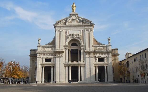 Façade of the Basilica of Santa Maria degli Angeli in Assisi, with the golden statue of the Madonna at the top.