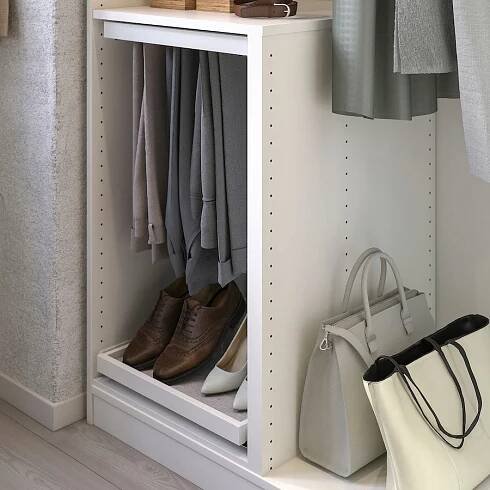 Bílý organizér do šatní skříně IKEA KOMPLEMENT, s horním a spodním panelem. Je navržen s přepážkou pro efektivní ukládání oblečení.