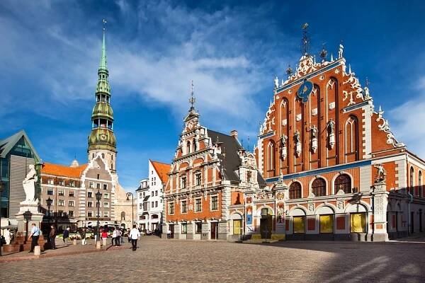Riga - Radniční náměstí s domem Černohlavců a protestantským kostelem sv. Petra vpozadí