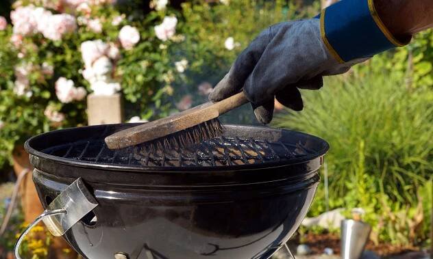 Cleaning the grill on a barbecue with a wire brush