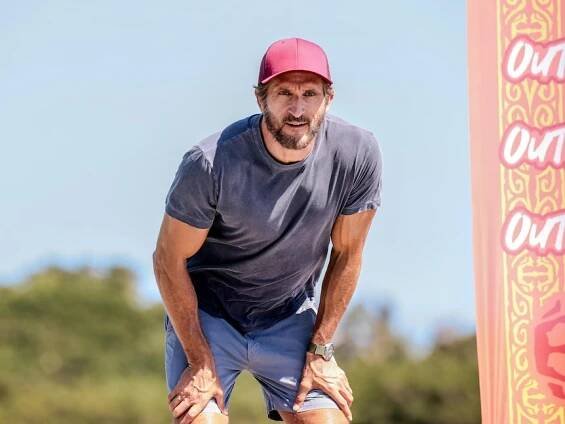 Jonathan LaPaglia looks focused during a SurvivorAU challenge, wearing a cap.