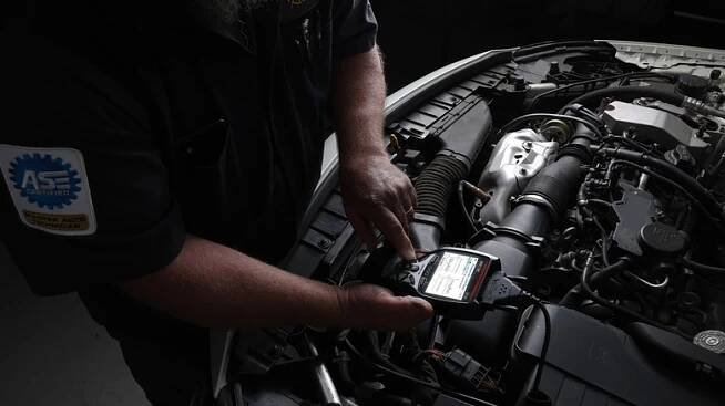 Mechanic diagnosing an open engine compartment with the 5610 Scanner