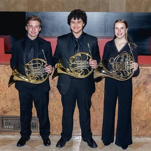 The french horn section of YWES posing after their winter concert in Robyn Newhouse Hall