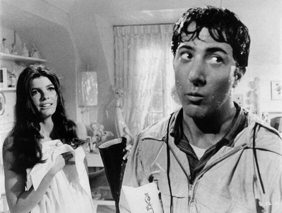 Katherine Ross covers herself with a sheet while holding a boot while Dustin Hoffman drips with water in a scene from the film 'The Graduate', 1967