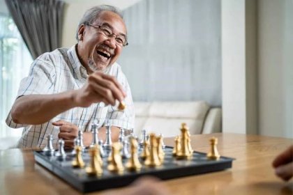 portrét asijského seniora staršího muže tráví volný čas, zůstává doma po odchodu do důchodu. šťastný usměvavý starý muž si užívá aktivitu v domácí šachové hře s přítelem. nemocniční zdravotní péče a lékařská koncepce - adult board games - stock snímky, obrázky a fotky