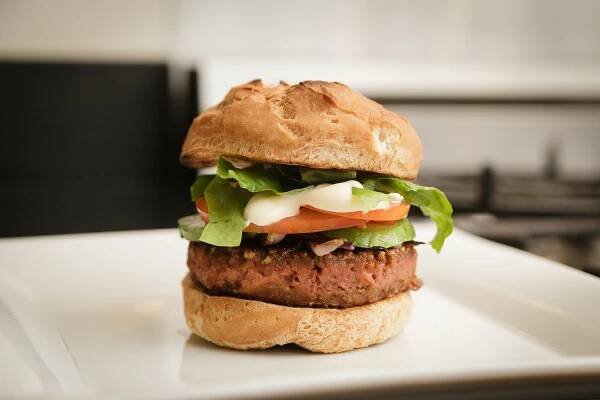 rganic burger made with Beyond Burger Veggie pattie in the kitchen with avocado, tomatoes and butter lettuce